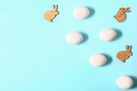 Natural Easter eggs and wooden bunny figures on color backgroundの写真素材