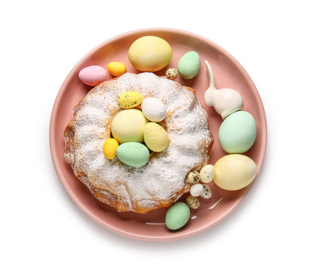Plate with sweet Easter cake and painted eggs on white backgroundの写真素材