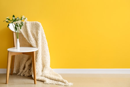 Vase with beautiful alstroemeria flowers on stool near yellow wallの写真素材