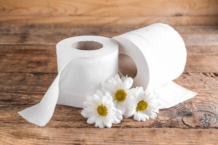 Rolls of toilet paper and chamomile flowers on wooden backgroundの写真素材