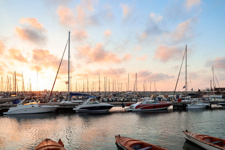 View of beautiful pier with yachts at sunsetの写真素材