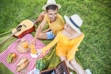 Happy young couple on picnic in parkの写真素材
