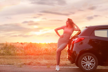 Young woman near car in countrysideの写真素材