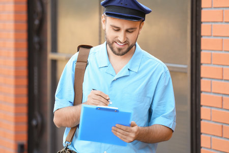 Handsome young post man outdoorsの写真素材