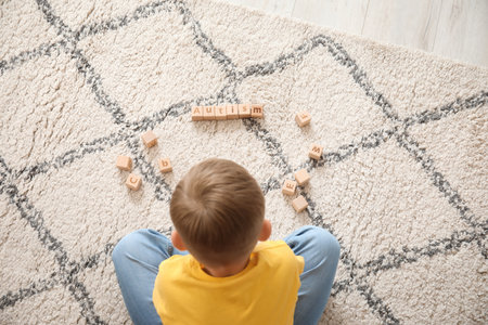 Little boy with autistic disorder playing with cubes at homeの写真素材