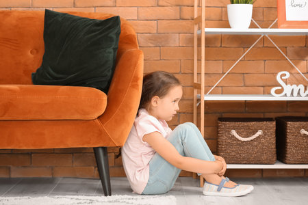 Sad little girl with autistic disorder at homeの写真素材