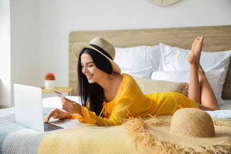 Woman with laptop booking tickets online at homeの写真素材