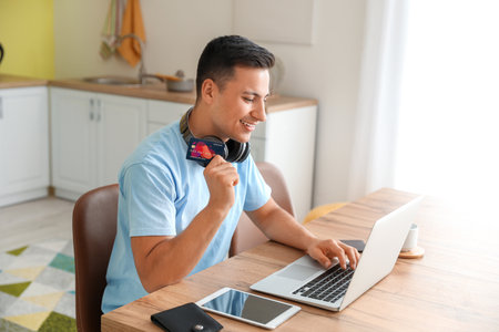 Man with laptop booking tickets online at homeの写真素材