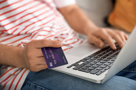 Man with laptop booking tickets online at homeの写真素材