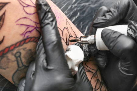 Professional artist making tattoo in salonの写真素材
