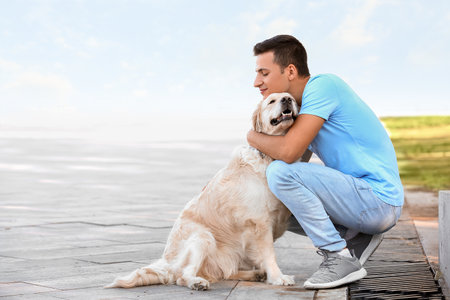 Young man with cute dog walking outdoorsの写真素材