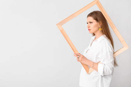 Beautiful young woman wearing stylish jewelry on light backgroundの写真素材