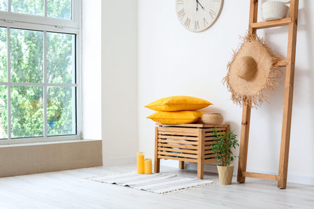 Interior of modern living room with chest of drawers and clock near white wallの写真素材