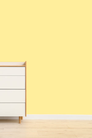 Modern chest of drawers near color wall in roomの写真素材