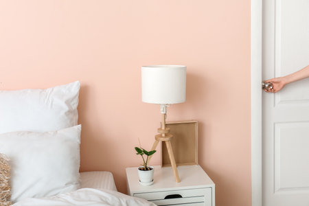 Woman opening door in modern stylish bedroomの写真素材