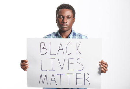 Sad African-American man with poster on white background. stop racismの写真素材