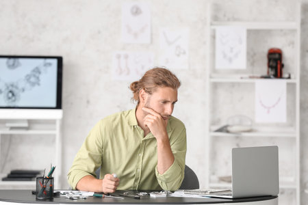 Male jewelry designer working in office