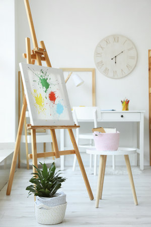 Interior of room with easel and painting suppliesの写真素材