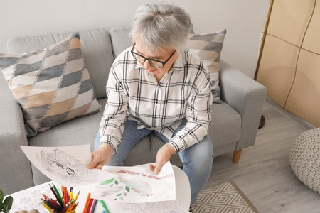 Senior woman coloring picture at homeの写真素材