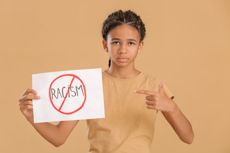 African-American girl with poster on color background. stop racismの写真素材