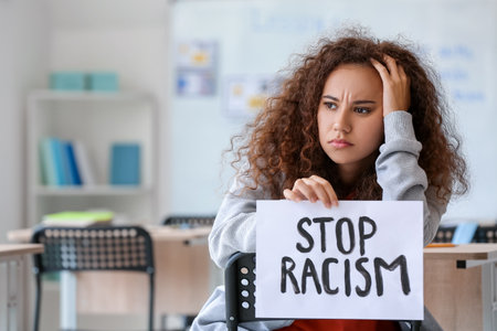 Sad African-American woman with poster at the university. stop racismの写真素材