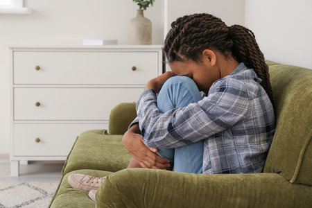 Sad African-American girl at home. stop racismの写真素材