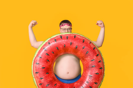 Overweight man with inflatable ring on color background. weight loss conceptの写真素材