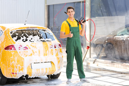 Worker of car wash cleaning modern automobileの写真素材