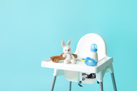 Baby highchair with food and toys on color backgroundの写真素材