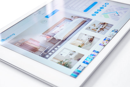 Open page of online booking service on screen of tablet computer, closeupの写真素材