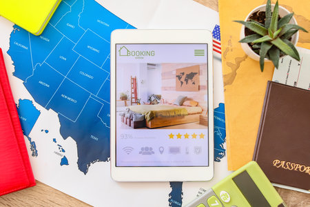 Open page of online booking service on screen of tablet computer on tableの写真素材