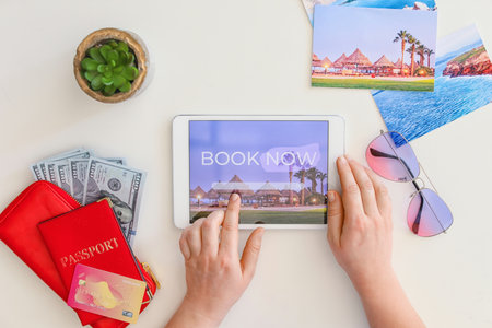 Woman with tablet computer booking tickets online at tableの写真素材