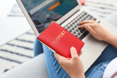 Woman with laptop booking tickets online at homeの写真素材