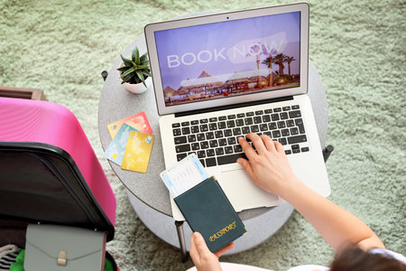 Woman with laptop booking tickets online at homeの写真素材