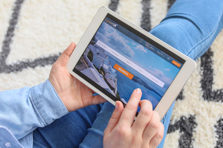 Woman with tablet computer booking tickets online at homeの写真素材