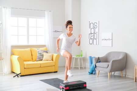 Sporty young woman training at homeの写真素材