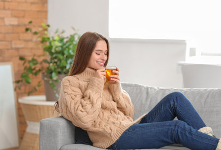 Beautiful young woman drinking tea at homeの写真素材