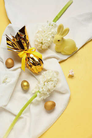Beautiful hyacinth flowers, Easter eggs and bunny on yellow backgroundの写真素材