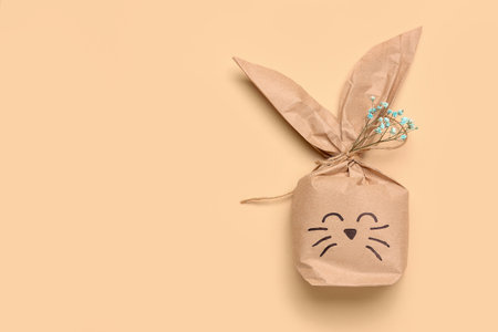 Easter bunny gift bag with gypsophila flowers on beige backgroundの写真素材