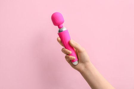 Woman with vibrator on pink backgroundの写真素材