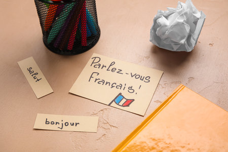 Papers with French words and stationery on beige background, closeupの写真素材