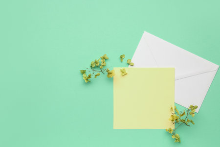 Composition with blank card, envelope and dried flowers on color backgroundの写真素材
