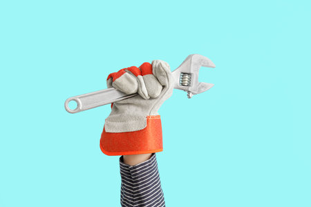 Female worker with wrench on blue backgroundの写真素材