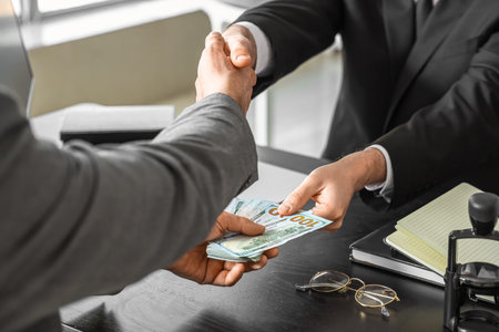 Business men with bribe shaking hands in office, closeup