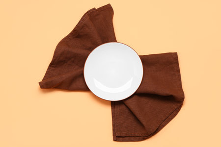 Empty plate and clean napkin on color backgroundの写真素材