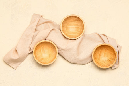 Composition with wooden bowls and napkin on light backgroundの写真素材