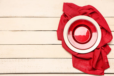Plate and red napkin on light wooden backgroundの写真素材