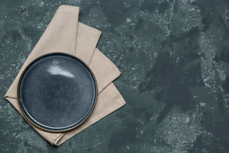 Plate with clean napkin on dark color backgroundの写真素材