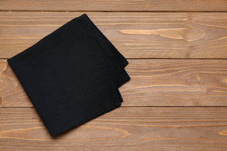 Black folded napkin on wooden backgroundの写真素材