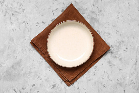 Folded napkin and empty plate on grunge backgroundの写真素材